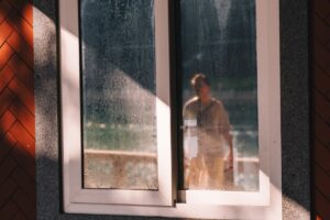 Adolescente pensativa olhando pela janela, representando ansiedade em adolescentes cristãs
