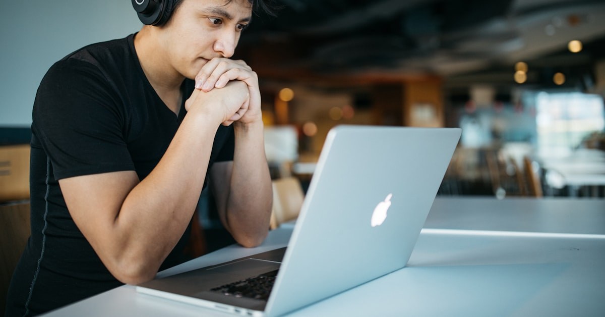 jovem com notebook refletindo sobre fé e inteligência artificial