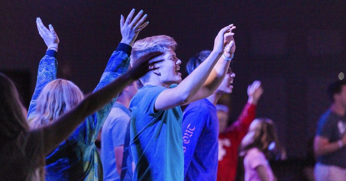 Líder conversando com jovens em círculo, representando liderança intencional de jovens na igreja