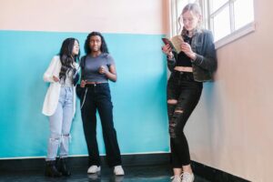 Adolescente com celular e líder ao fundo em comunidade cristã, representando o ECA Digital e a liderança de adolescentes Adolescente com celular e líder ao fundo em comunidade cristã, representando o ECA Digital e a liderança de adolescentes
