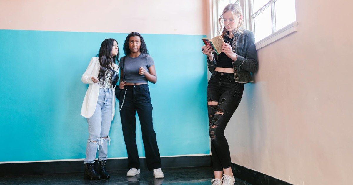 Adolescente com celular e líder ao fundo em comunidade cristã, representando o ECA Digital e a liderança de adolescentes
