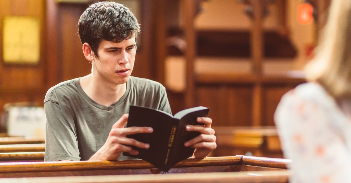 Adolescente lendo a Bíblia em banco de igreja, representando liberdade e fé cristã