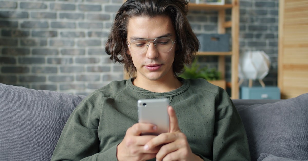 Adolescente usando smartphone em casa: a presença pastoral digital começa onde o adolescente mora