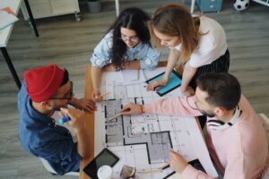 Grupo de adolescentes colaborando em projeto ao redor de uma mesa, representando engajamento de adolescentes no ministério