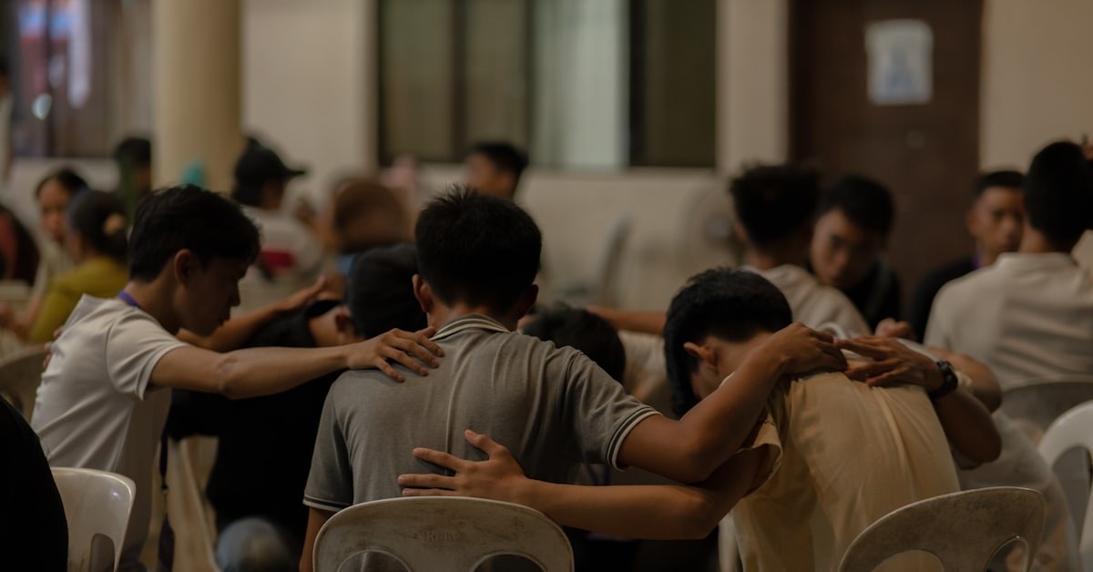 Adolescentes orando em grupo, representando a prática de oração intercessória no ministério de adolescentes