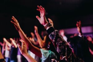 Adolescentes cristãos em momento de adoração com mãos levantadas, representando a fé que se forma antes dos grandes palcos da vida Adolescentes cristãos em momento de adoração com mãos levantadas, representando a fé que se forma antes dos grandes palcos da vida
