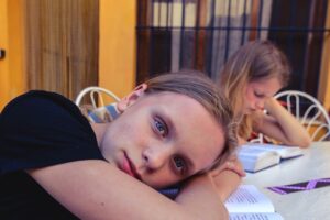 Adolescente cristã estudando com expressão preocupada, representando o perfeccionismo e a autocobrança na fé