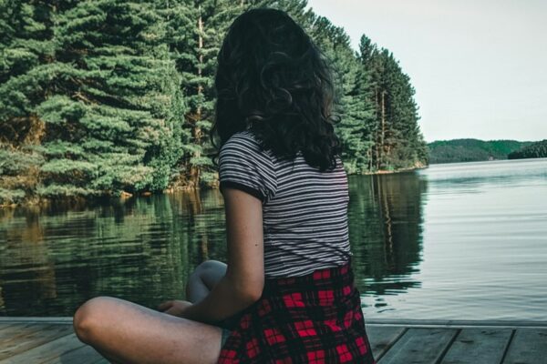 adolescente sentada sozinha em floresta, reflexiva