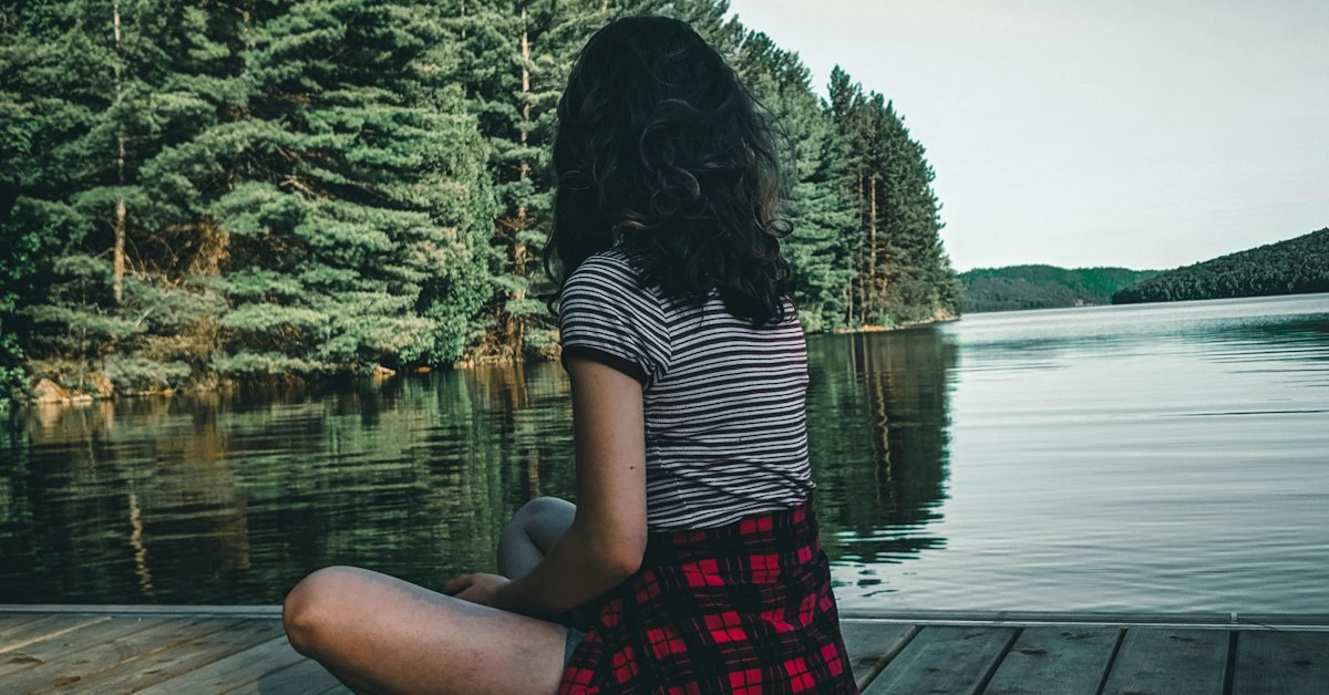 adolescente sentada sozinha em floresta, reflexiva
